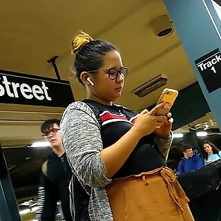 Søt lubben filipina jente med briller venter på tog